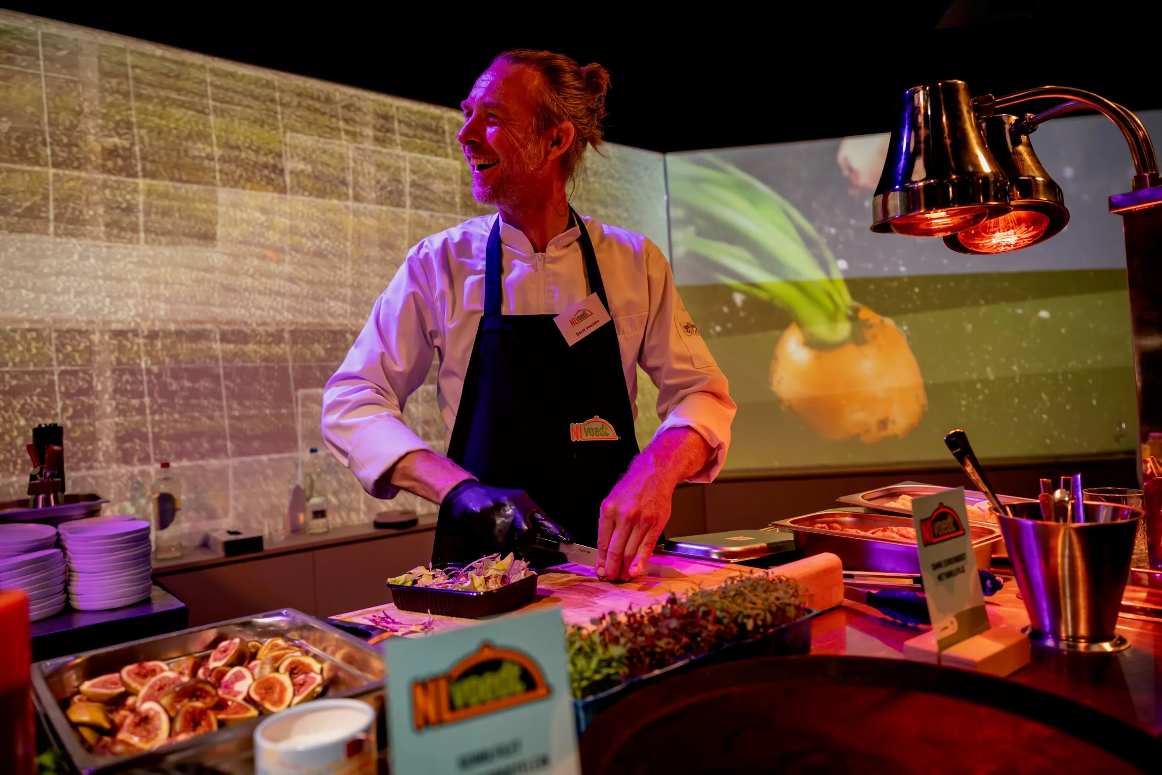 Chef David lachend achter kookstation